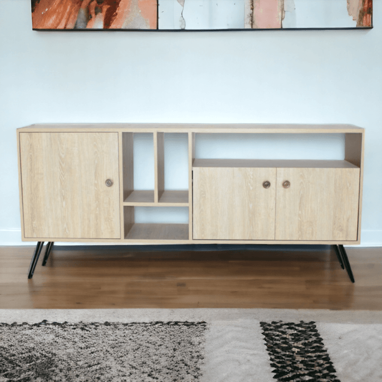 El mueble de la imagen es un aparador de madera clara con un diseño contemporáneo. Tiene una estructura rectangular con una superficie amplia en la parte superior. Presenta dos compartimentos cerrados con puertas, uno en cada extremo; el compartimento de la izquierda tiene una sola puerta, mientras que el de la derecha tiene dos puertas pequeñas. Entre estos compartimentos hay varios estantes abiertos, incluyendo un espacio rectangular grande en la parte superior y varios estantes más pequeños en el medio. El mueble se apoya sobre cuatro patas metálicas negras inclinadas, que le proporcionan un estilo moderno y ligero.