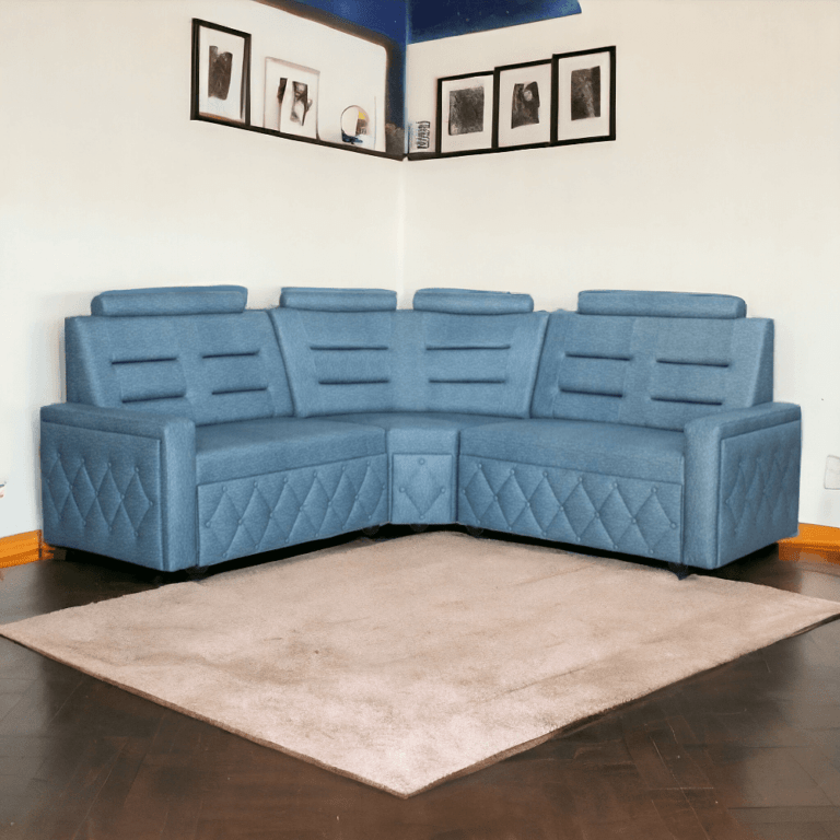 La imagen muestra una sala seccional en forma de L, tapizado en tela de color azul claro. El diseño del sofá incluye respaldos altos con cabeceras ajustables y detalles horizontales que brindan un aspecto moderno y elegante. Los costados del sofá presentan un patrón de rombos acolchados, añadiendo un toque de sofisticación al diseño. La parte inferior del sofá está equipada con pequeñas patas negras que elevan ligeramente la estructura del suelo.