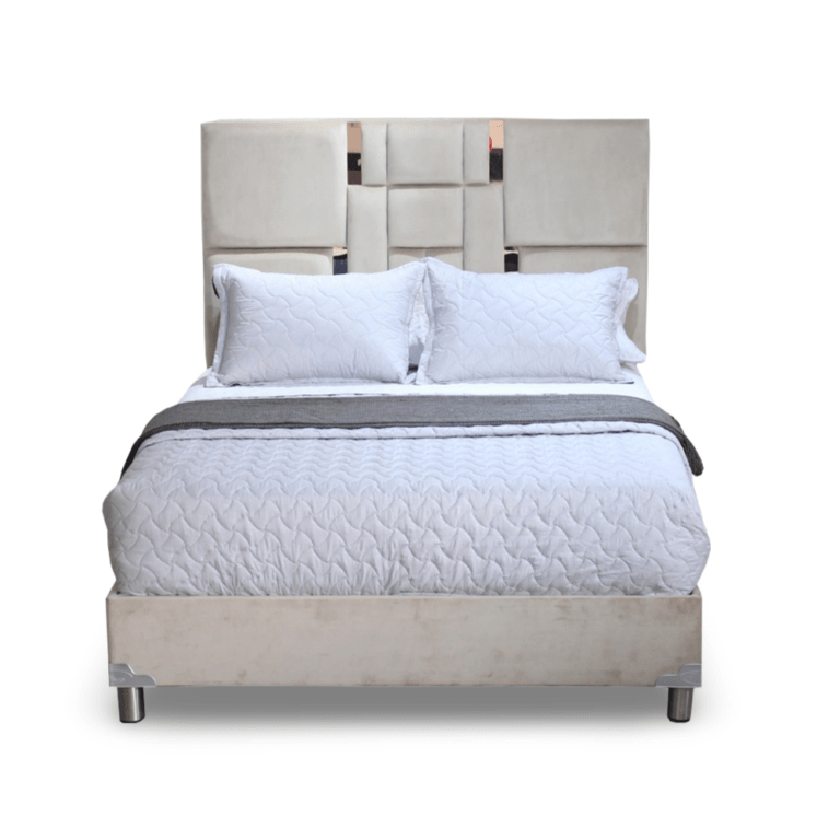 La imagen muestra una cama con un diseño moderno y sofisticado. La cama tiene un cabecero alto tapizado en tela color beige, con un patrón geométrico de paneles acolchados que le da un toque de elegancia y estilo. La base de la cama también está tapizada en el mismo material y color que el cabecero. Las patas de la cama son de metal, proporcionando un soporte robusto y un aspecto contemporáneo. El colchón es de color blanco con una funda acolchada que presenta un patrón de costura en forma de ondas.