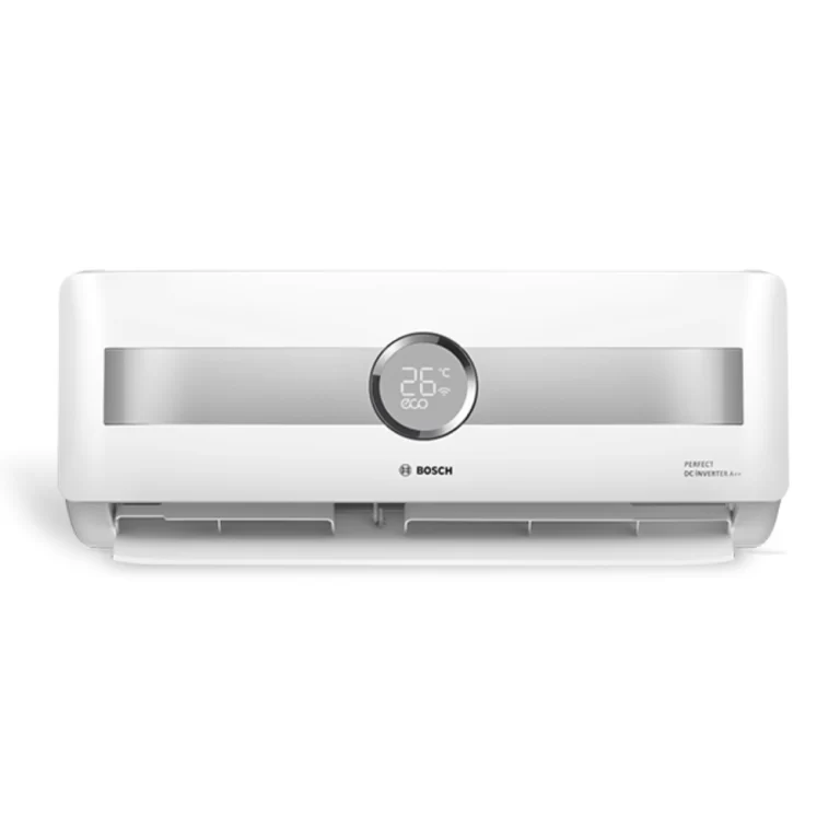 dispositivo tiene un diseño moderno y elegante, con un acabado blanco brillante. En el centro del panel frontal, se encuentra una pantalla digital redonda que muestra la temperatura actual y un ícono de "eco". A ambos lados de la pantalla, hay una franja gris que añade un toque estético al diseño. La unidad cuenta con una abertura en la parte inferior, donde se encuentran las salidas de aire. Debajo de la pantalla digital, el logotipo de Bosch está claramente visible.