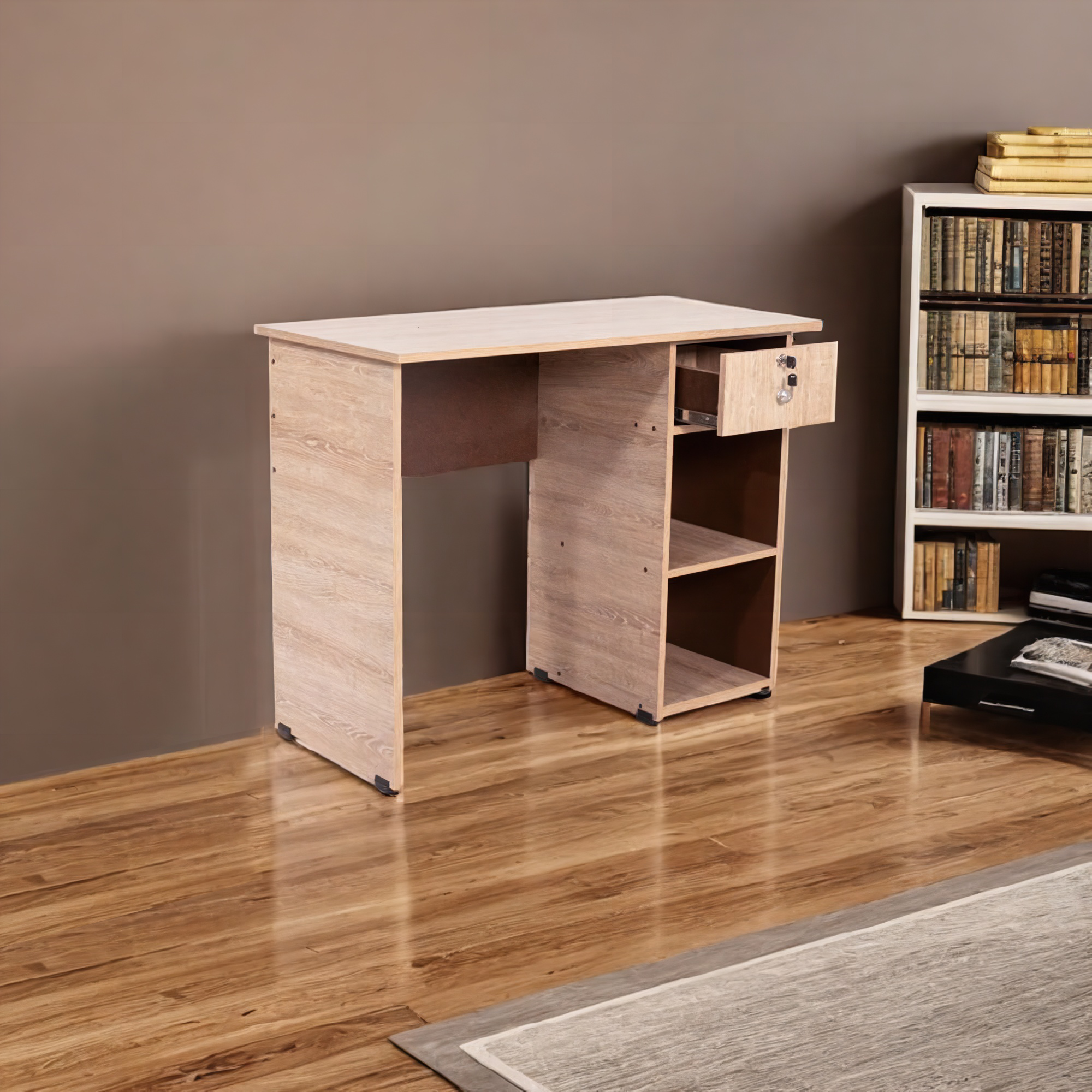 La imagen muestra un escritorio de color madera clara con un diseño minimalista y funcional. El escritorio tiene una superficie de trabajo rectangular y una estructura de soporte sencilla. A la derecha, hay una unidad de almacenamiento con un cajón superior parcialmente abierto y dos estantes abiertos debajo.